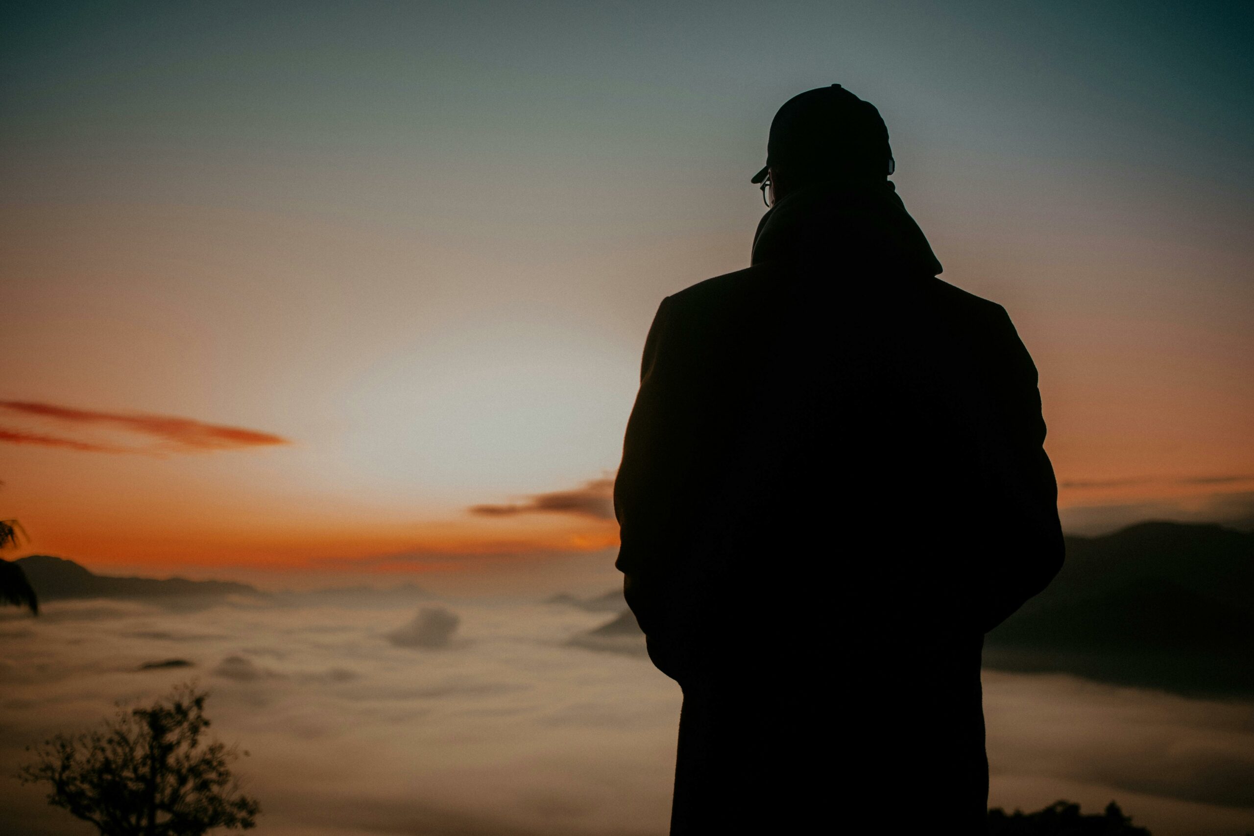 Person standing at sunrise symbolizing hope and recovery from gambling addiction